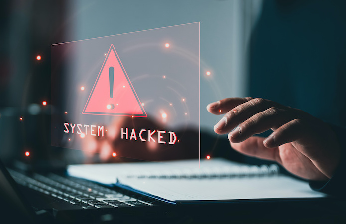 A red 'System hacked' alert shows after a cyber attack on a computer network.