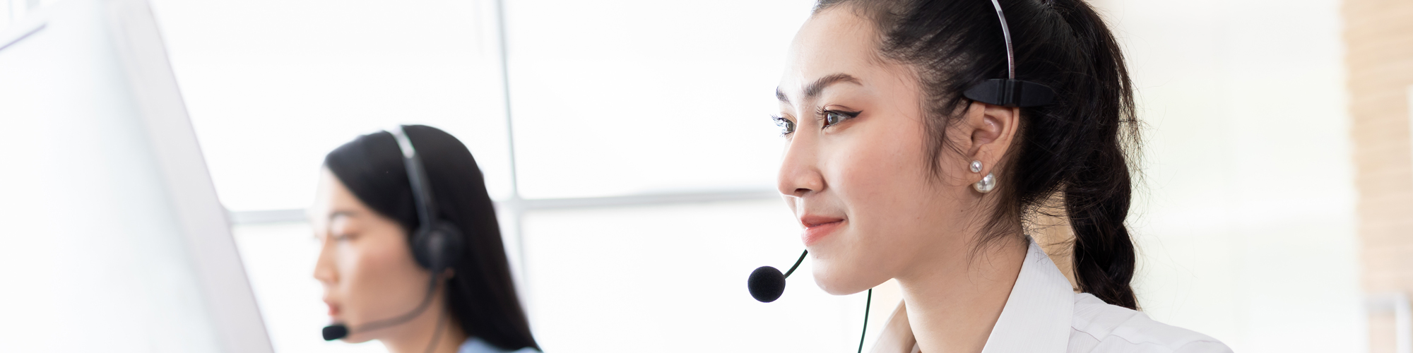 Two Young Women Talking On Phone Headsets